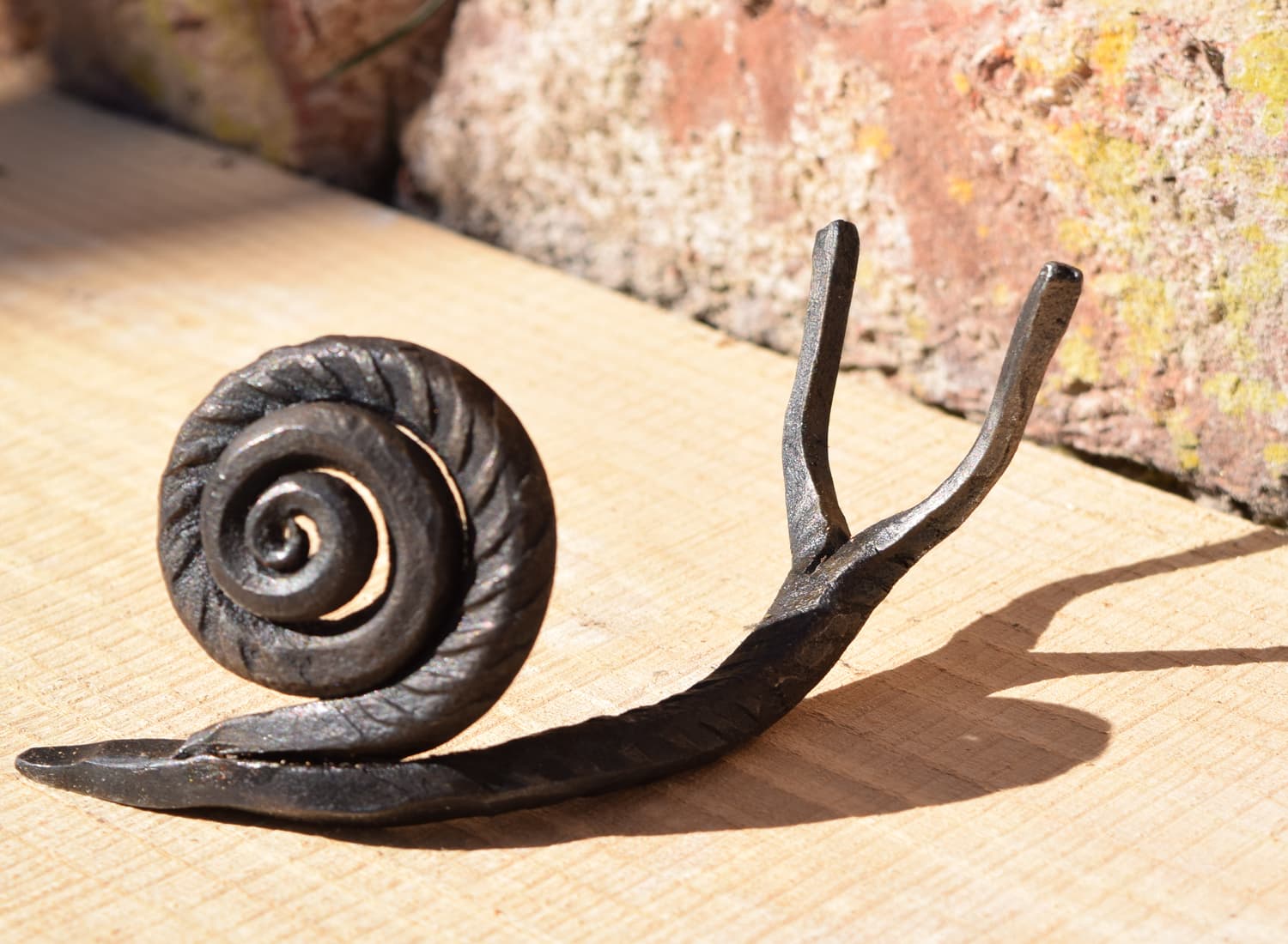 Handcrafted metal snail sculpture with spiral shell